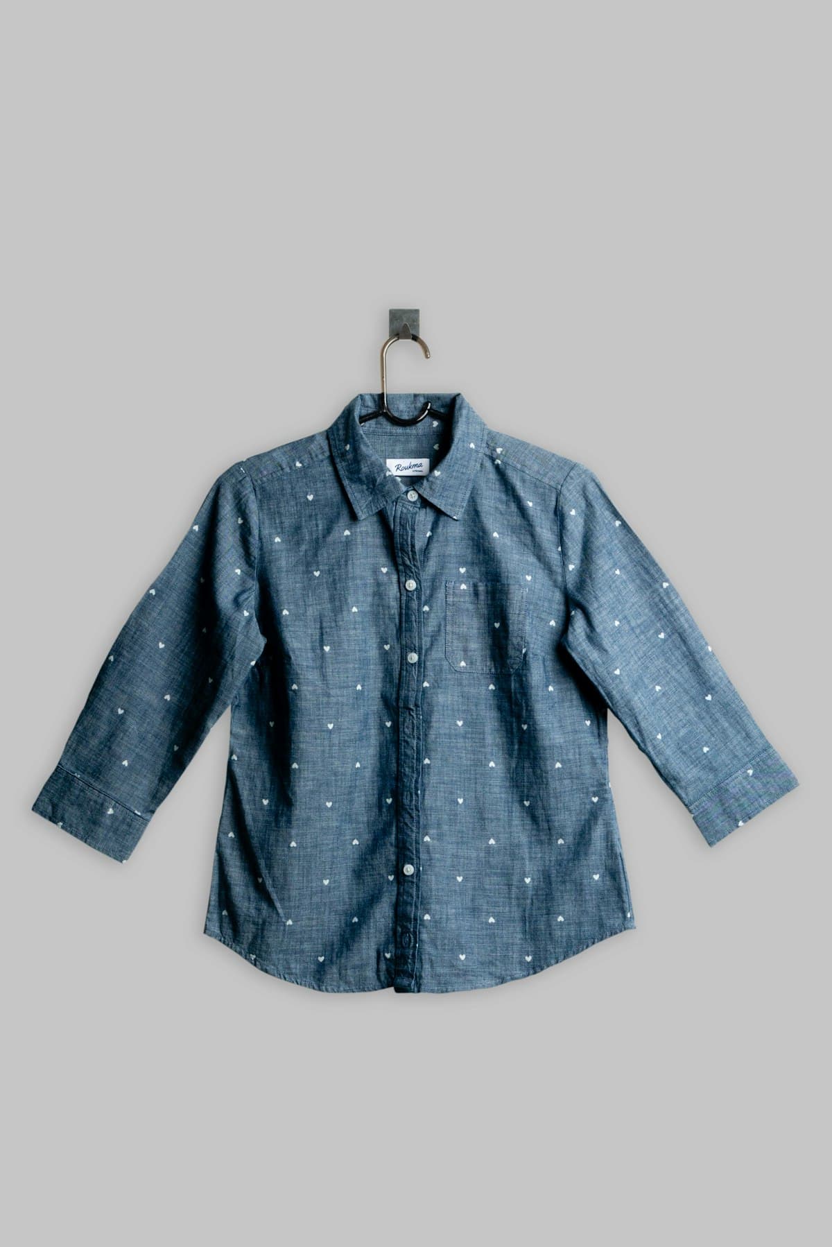 Camisa azul com microestampa pendurada em cabide