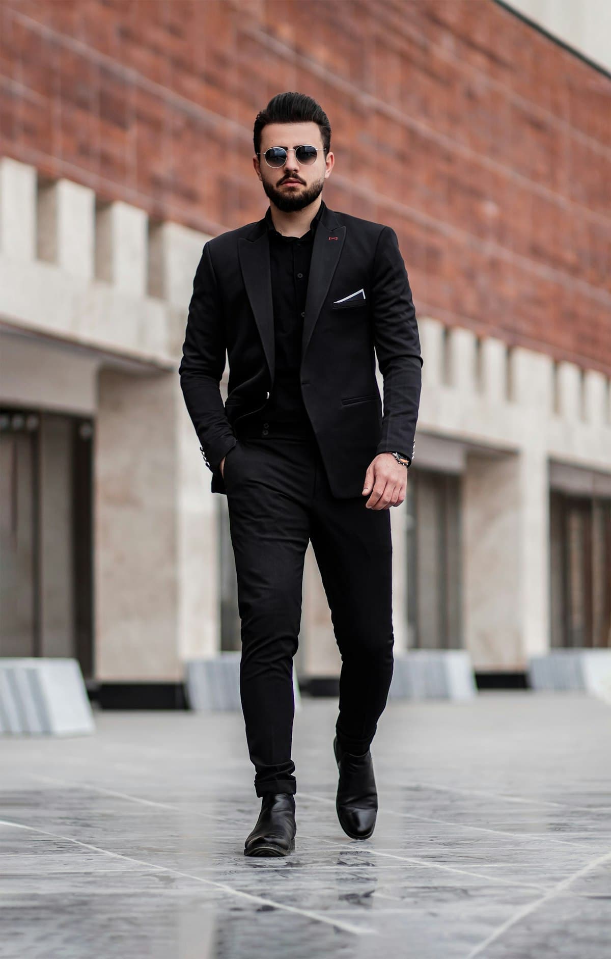 Homem de traje preto caminhando na cidade